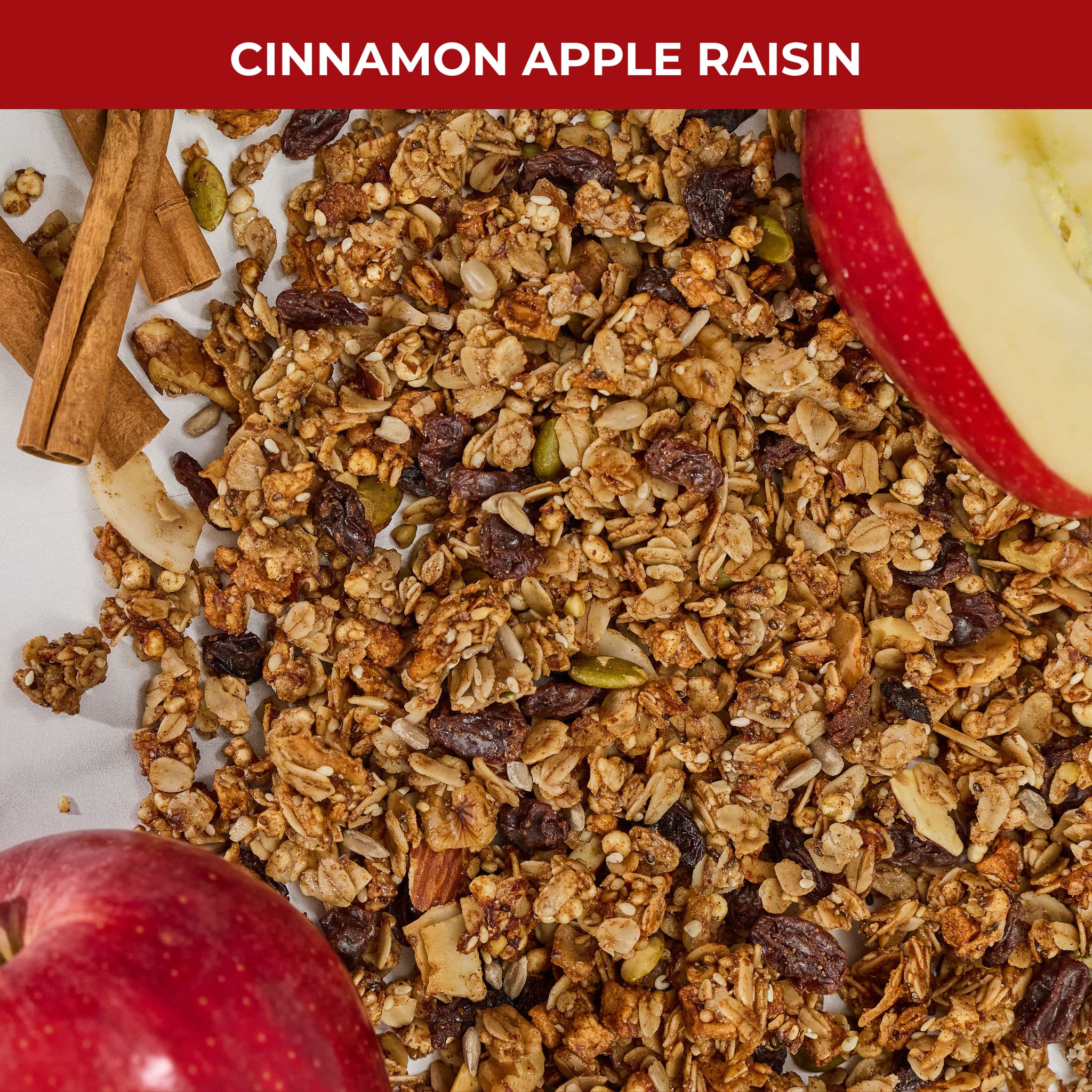Detail shot of Cinnamon Apple Raisin granola texture showing apple pieces, raisins, and cinnamon sticks with label 'Cinnamon Apple Raisin'