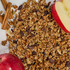 Detail shot of Cinnamon Apple Raisin granola texture showing apple pieces, raisins, and cinnamon sticks.