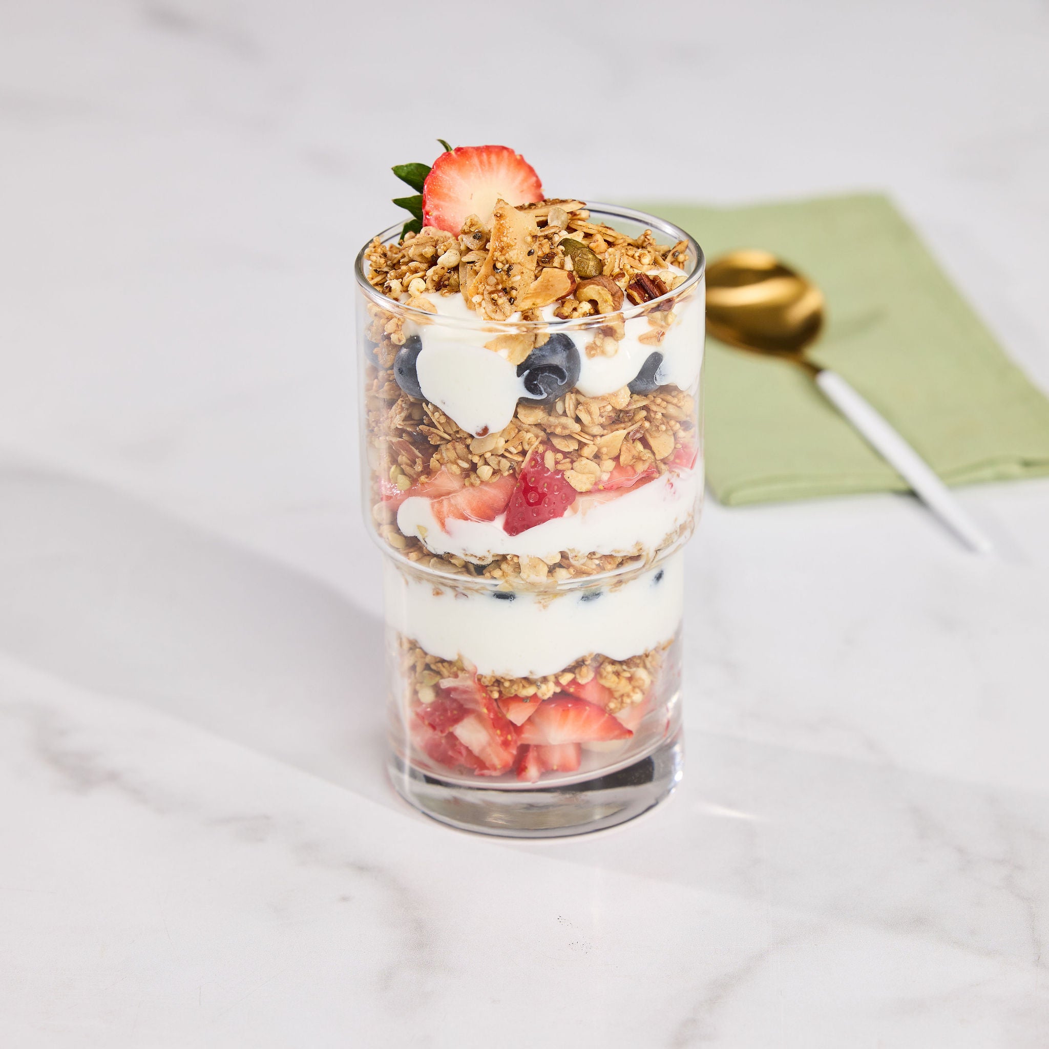Delicious gutBFF Honey Glow prebiotic superfood granola with lion's mane mushroom, layered in a yogurt and berry parfait for a gut-healthy breakfast