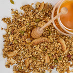Close-up view of Honey Glow granola clusters showing ancient grains, seeds, nuts, and honey.