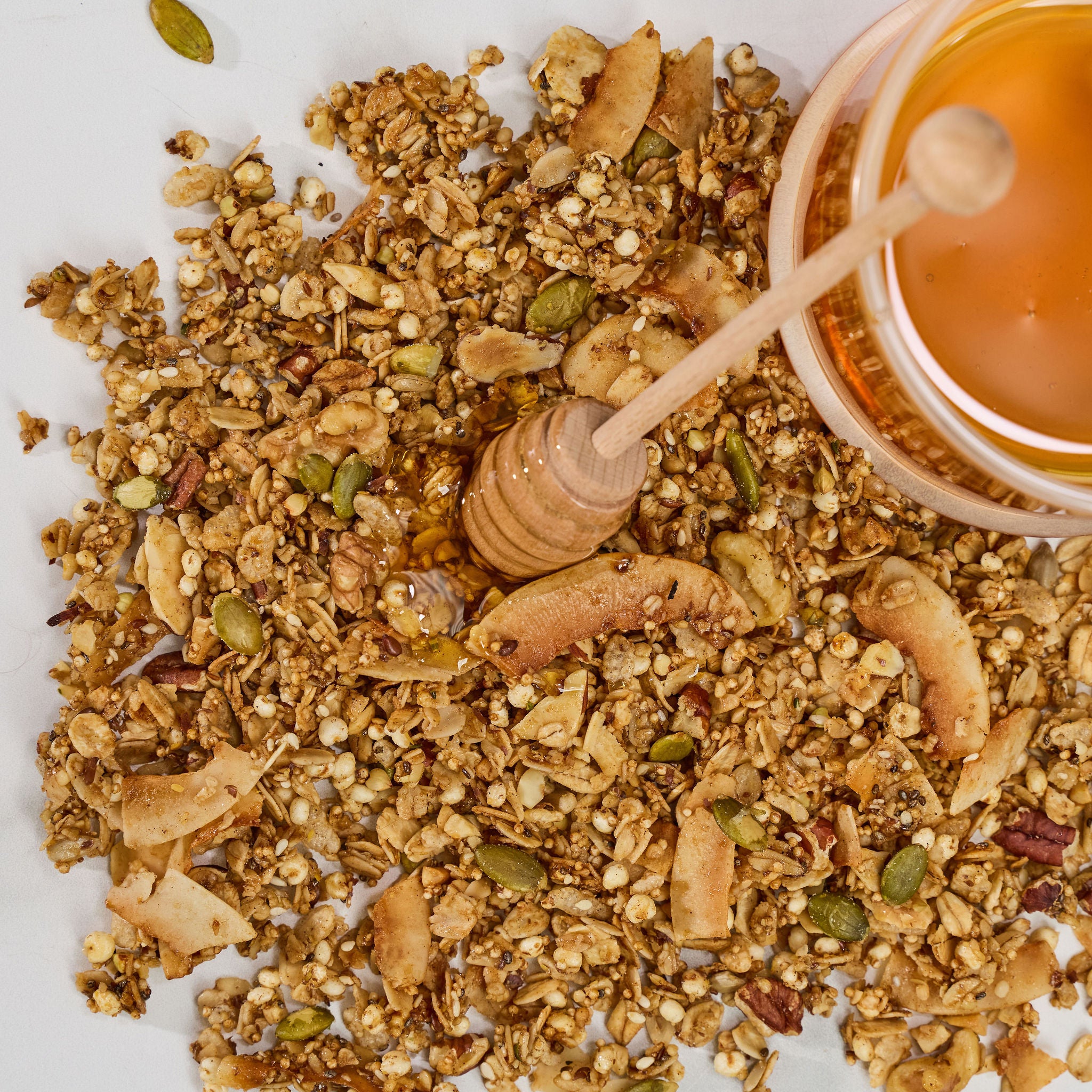 Close-up view of Honey Glow granola clusters showing ancient grains, seeds, nuts, and honey.